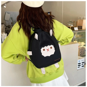 Détail d'un sac à dos mouton noir avec des oreilles en 3D et une applique en polaire