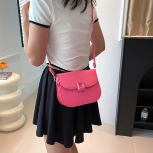 Hot pink minimalist PU leather crossbody saddle bag with decorative buckle shown on model