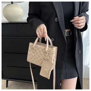 Detail of beige quilted crossbody bag with matching mini pouch and gold hardware accents