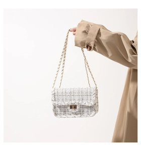 Détail d'un sac en tweed blanc avec fermoir doré et bandoulière en chaîne chic