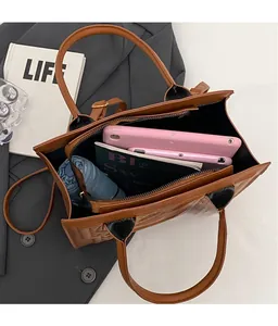 Internal view of a brown tote bag showing spacious capacity for tablets and books