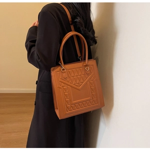 Detail shot of the camel PU leather square bag with unique 3D geometric embossed pattern