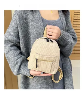 Detailed texture of beige corduroy backpack with front zipper pocket and soft fabric