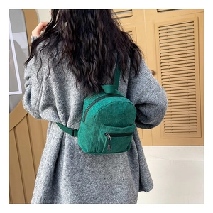 Green corduroy backpack on model back showing texture and adjustable straps