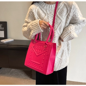 Detail of hot pink quilted tote bag with geometric texture and dual-use shoulder strap