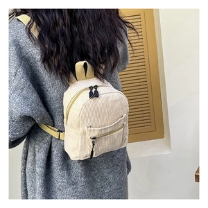 Detail shot of a beige corduroy backpack texture with yellow straps on a person