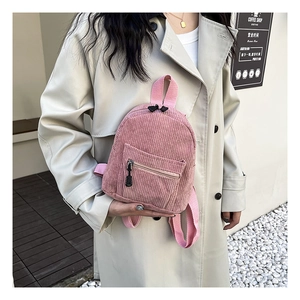 Detail of pink corduroy mini backpack with vertical texture and dual zippers