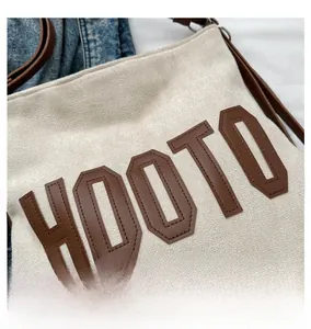 Close-up of the HOOTO letter stitching and high-quality suede texture on the tote bag