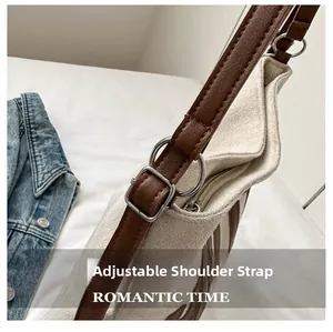 Detail of adjustable leather shoulder strap with silver buckle on canvas tote bag