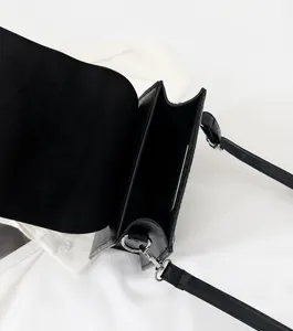 Vue de dessus du compartiment intérieur spacieux et de la bandoulière de ce sac noir chic