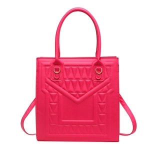 Vibrant magenta crossbody bag with geometric embossed pattern and gold hardware