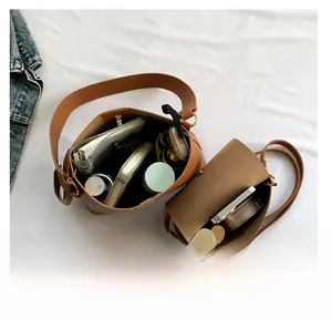 Internal capacity view of brown leather bucket bag and small crossbody bag set