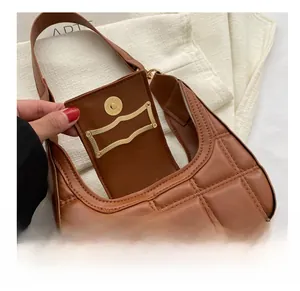 Detailed view of the gold magnetic closure on a brown quilted crescent shoulder bag