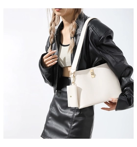 Chic off-white bucket bag set worn by a model in a trendy black outfit