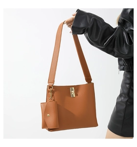 Detail of brown leather bucket bag set with gold clasp and matching mini pouch