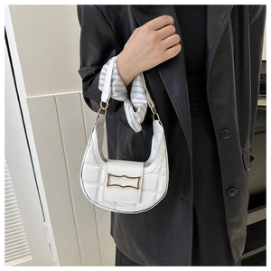 Detail of white quilted crescent bag with a gold buckle worn with a black leather coat