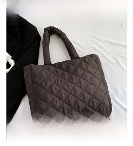 Gros plan du sac fourre-tout matelassé marron avec surpiqûres en losange et nylon bouffant