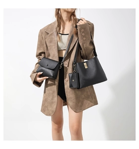 Detailed view of 3-piece black leather bag set including bucket bag and crossbody pouch