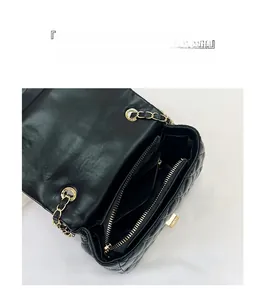 Detailansicht der Innenfächer und der goldfarbenen Kette der schwarzen Stepptasche