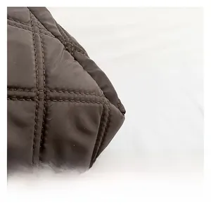 Vue macro du tissu en nylon matelassé marron foncé avec coutures doubles détaillées