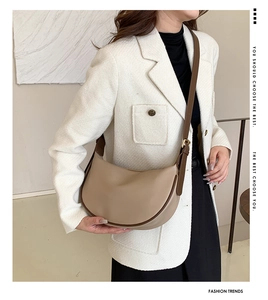 Detail of soft leather crescent bag in beige with adjustable brown shoulder strap