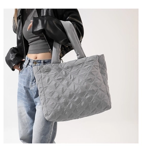 Détail macro du sac cabas en duvet gris matelassé avec tissu en nylon imperméable