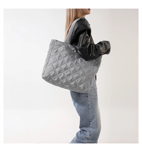 Grand sac cabas matelassé gris foncé avec motif en losange porté par un mannequin