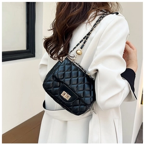 Detailansicht der schwarzen gesteppten Ledertasche mit goldener Kette und Anhänger