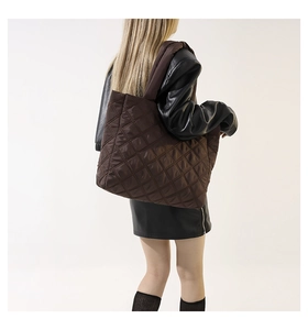 Détail d'un grand sac cabas matelassé marron foncé avec motif losange sur mannequin