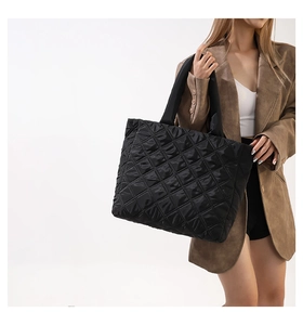 Détail du sac cabas matelassé noir en nylon brillant avec larges anses rembourrées