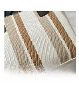 Macro shot of striped canvas tote bag showing detailed beige and brown woven texture