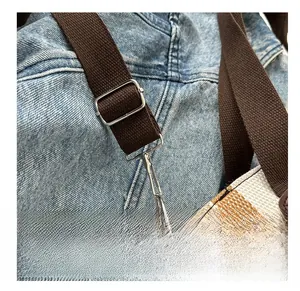 Detail of silver alloy hook and canvas strap with metal adjustment buckle on tote bag