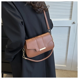 Brown faux leather crossbody bag with golden metal buckle shown as a crossbody view