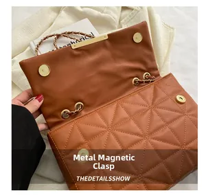 Détail du sac matelassé marron avec fermoirs magnétiques et bandoulière en chaîne