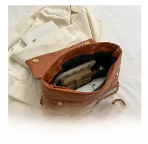 Gros plan sur l'intérieur spacieux d'un sac bandoulière marron matelassé tendance