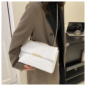 Vue détaillée d'un sac bandoulière blanc matelassé avec chaîne dorée sur mannequin