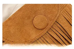 Détail du sac à franges en daim marron montrant l'artisanat et les pompons verticaux