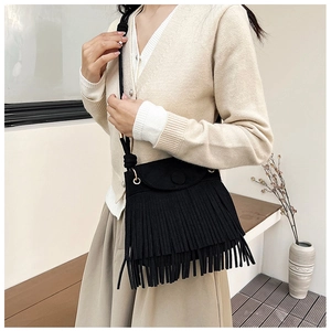 Détail du sac à bandoulière noir à franges avec texture mate et longues franges