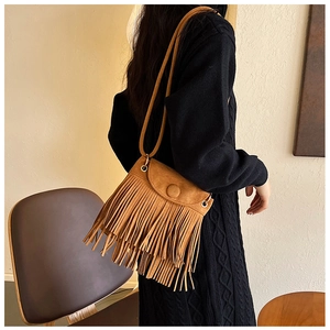 Détail d'un sac à bandoulière en PU marron avec des franges et une boucle métallique