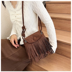 Détail du sac bandoulière en daim marron avec de longues franges et boucle ronde