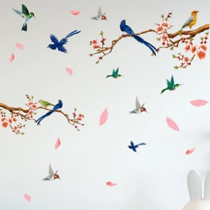 Detail of colorful bird and pink cherry blossom wall stickers on a clean white background