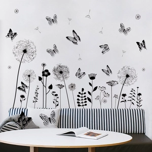 Macro detail of black dandelion and butterfly wall stickers on a modern living room wall