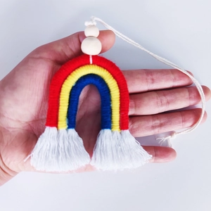 Détail d'un pendentif arc-en-ciel tissé à la main avec cordes en coton et franges
