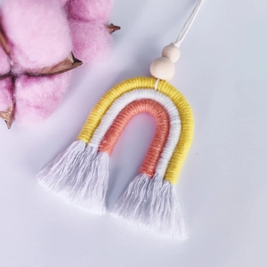 Détail d'une décoration arc-en-ciel en macramé avec perles en bois et franges artisanales