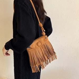 Sac bandoulière marron à franges en daim porté par un mannequin vue de profil