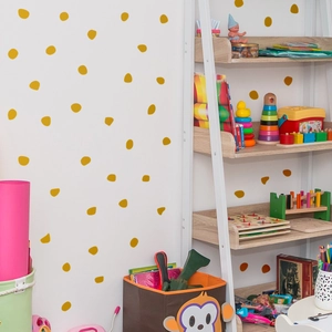Detail of gold irregular polka dot wall stickers in a cozy nursery room setting