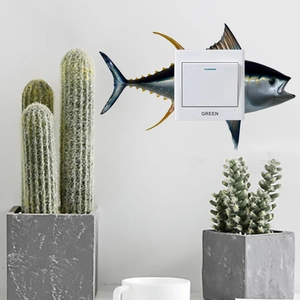 Creative fish wall sticker detail on a modern light switch with realistic tuna texture