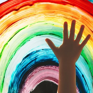 Close-up of rainbow static window sticker with vibrant textures and hand silhouette