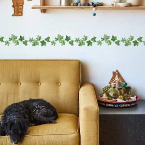 Detail of green ivy leaf wall stickers above a sofa in a natural living room decor