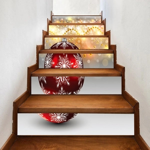 Macro detail of Christmas stair stickers with red bauble and gold beads on wooden steps